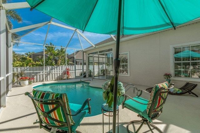 view of pool with a patio area and glass enclosure