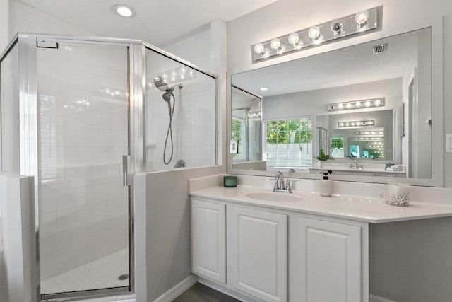 bathroom with vanity and a shower with door