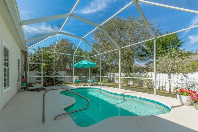 view of swimming pool featuring glass enclosure and a patio area