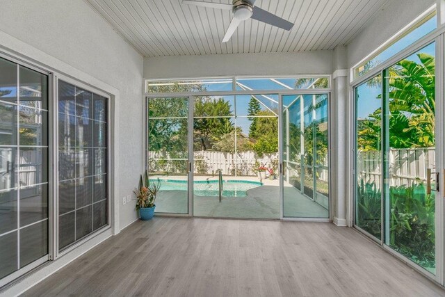 unfurnished sunroom with wood ceiling and ceiling fan