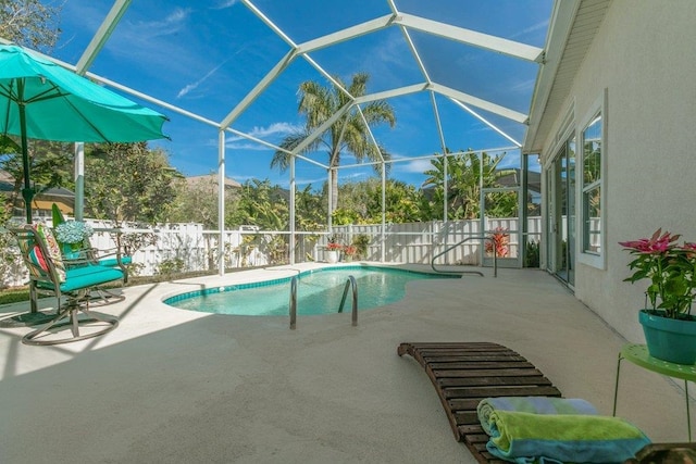 view of pool with a patio area and glass enclosure