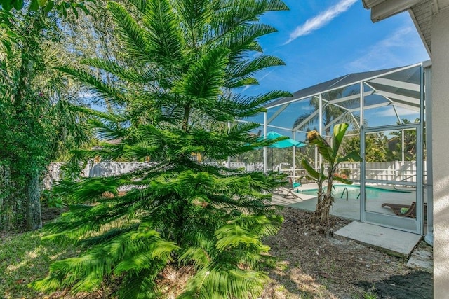 view of yard with a lanai, a fenced in pool, and a patio area