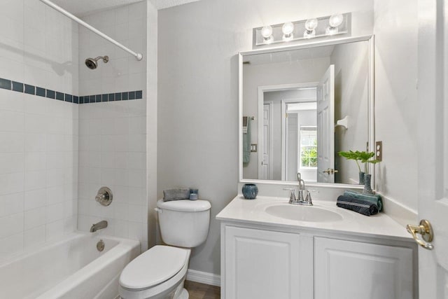 full bathroom with tiled shower / bath combo, vanity, and toilet