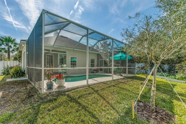 back of property featuring a fenced in pool, a patio area, glass enclosure, and a lawn