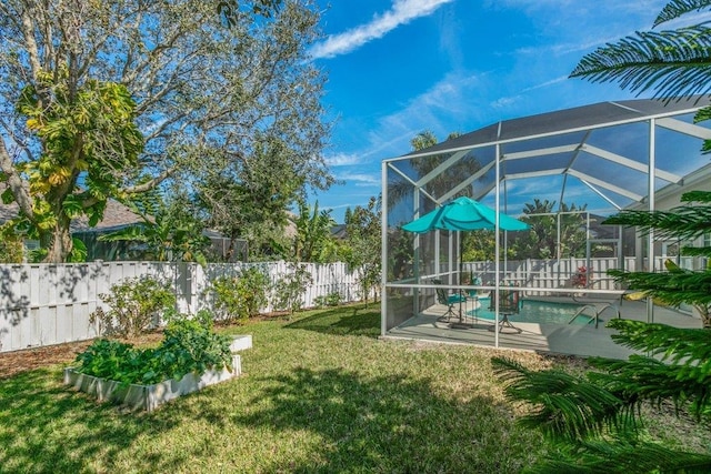 view of yard featuring a fenced in pool, a patio, and glass enclosure