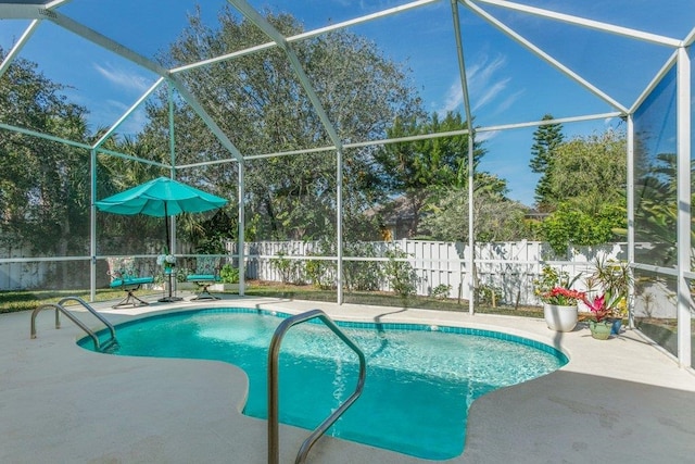 view of swimming pool featuring glass enclosure and a patio area