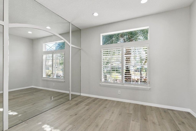 unfurnished bedroom with light hardwood / wood-style floors and a textured ceiling