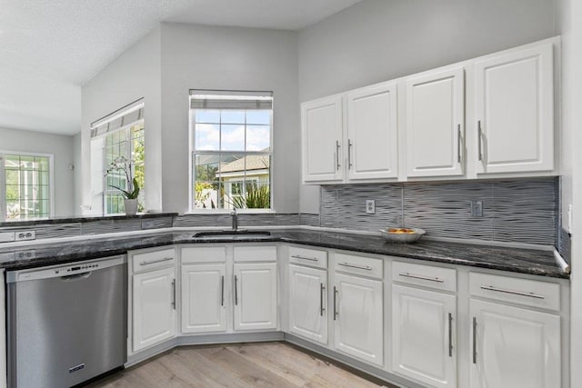 kitchen with dark stone counters, dishwasher, sink, and white cabinets