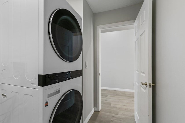 clothes washing area with stacked washer and clothes dryer and light hardwood / wood-style floors