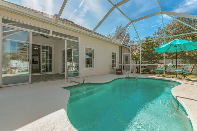 view of pool with glass enclosure and a patio