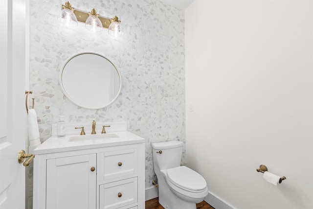 211 2nd St, Saint Augustine, FL 32080 - half bath with vanity, wallpapered walls, and wood finished floors