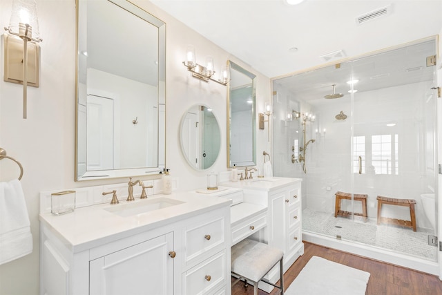 bathroom with a shower with door, vanity, and hardwood / wood-style flooring