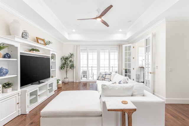 living room featuring a tray ceiling, french doors, and dark wood-type flooring