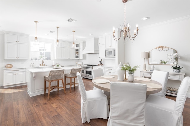 dining room featuring crown molding, dark hardwood / wood-style flooring, sink, and a chandelier