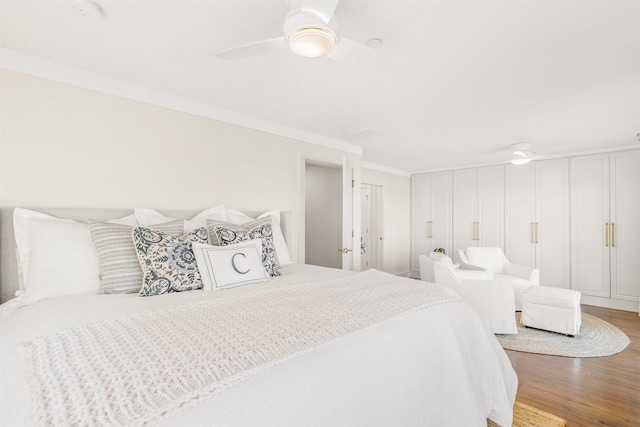 bedroom with ceiling fan, wood-type flooring, and crown molding