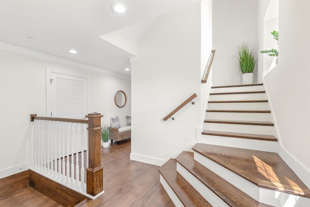 staircase featuring hardwood / wood-style floors and ornamental molding