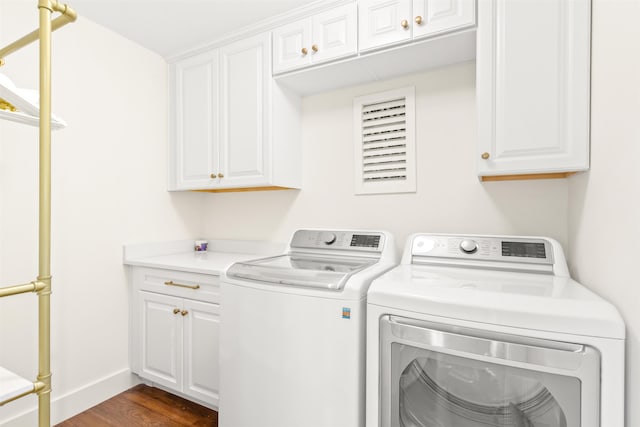 laundry room featuring washer and clothes dryer, cabinets, and dark hardwood / wood-style floors