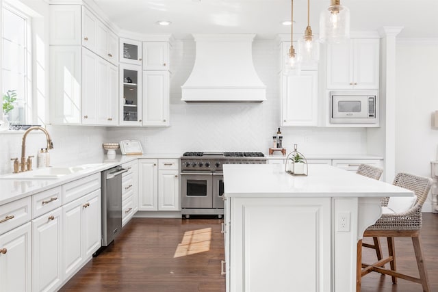 kitchen featuring a center island, sink, hanging light fixtures, stainless steel appliances, and custom range hood