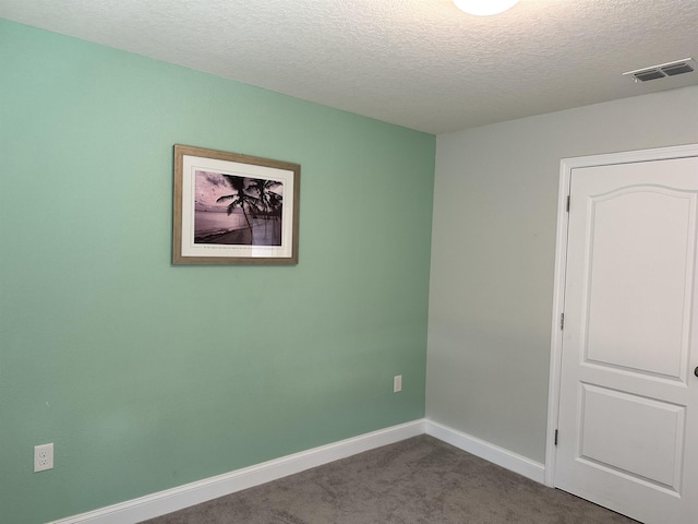 carpeted spare room featuring a textured ceiling