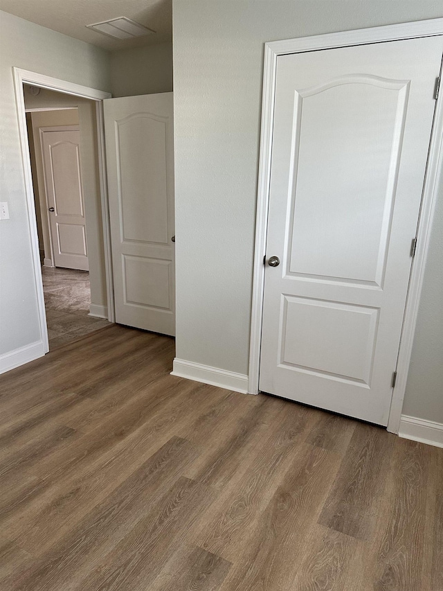 unfurnished bedroom featuring dark hardwood / wood-style flooring