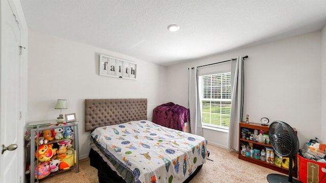 bedroom with light carpet and a textured ceiling