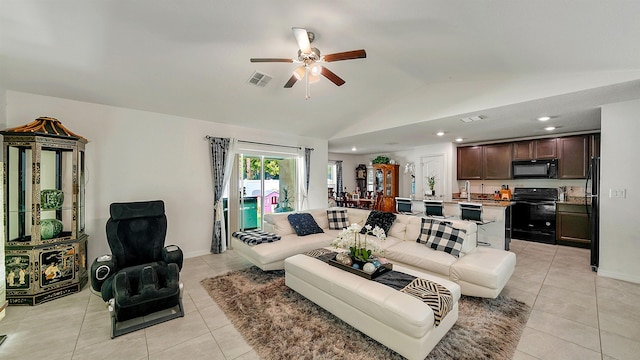 living room with vaulted ceiling, ceiling fan, and light tile patterned flooring