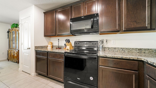 kitchen with black appliances, dark brown cabinets, light tile patterned flooring, and light stone countertops