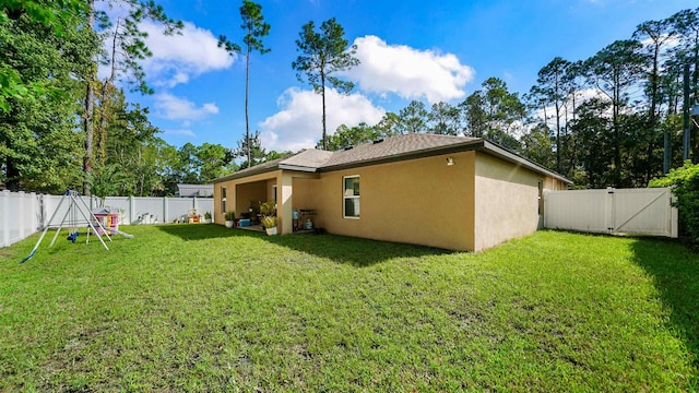 rear view of property featuring a lawn