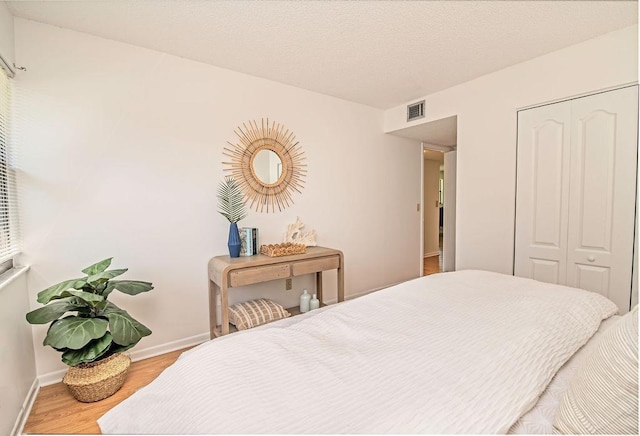 bedroom with a closet and hardwood / wood-style floors