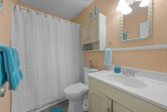 bathroom featuring vanity, wooden walls, tile patterned flooring, toilet, and a textured ceiling