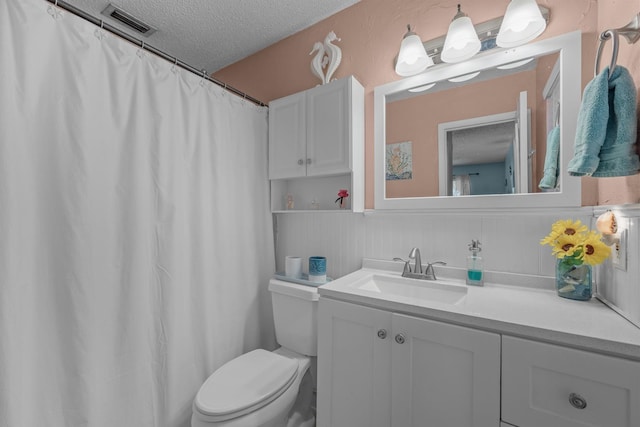 bathroom featuring vanity, toilet, and a textured ceiling