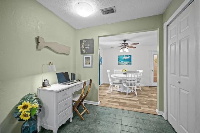 office area featuring a textured ceiling, ceiling fan, and dark wood-type flooring