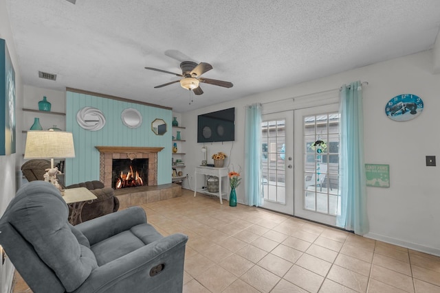 living room with light tile patterned flooring, french doors, a textured ceiling, ceiling fan, and wood walls