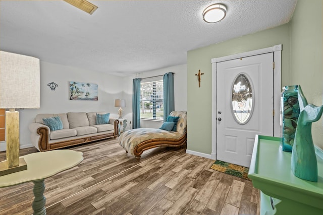 entrance foyer with hardwood / wood-style floors and a textured ceiling