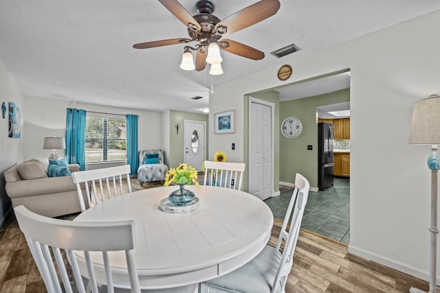 dining area with ceiling fan and wood-type flooring