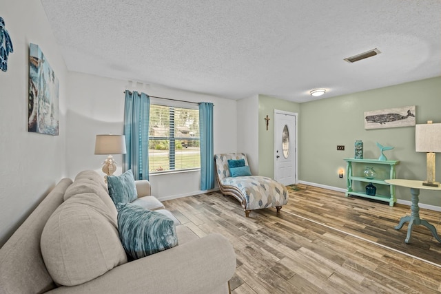 sitting room featuring wood-type flooring and a textured ceiling