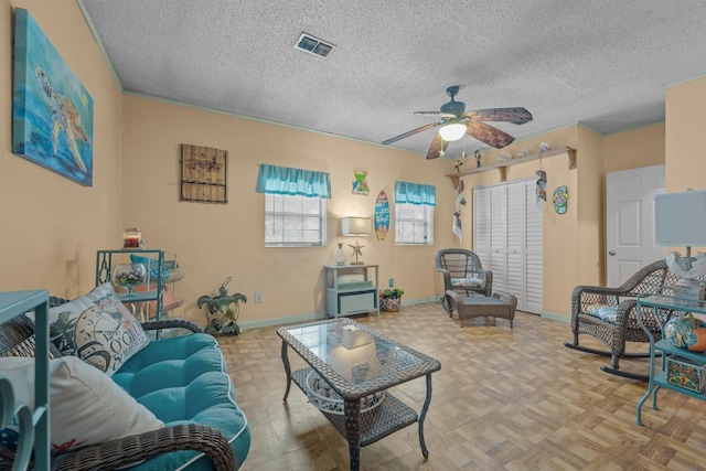 living room with ceiling fan, a textured ceiling, and light parquet floors