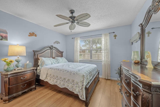 bedroom with a textured ceiling, light wood-type flooring, and ceiling fan