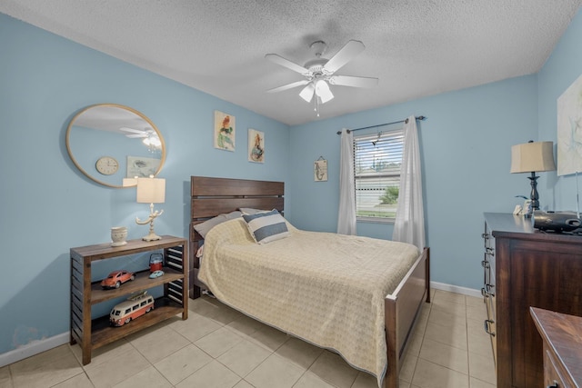 bedroom with ceiling fan, light tile patterned floors, and a textured ceiling