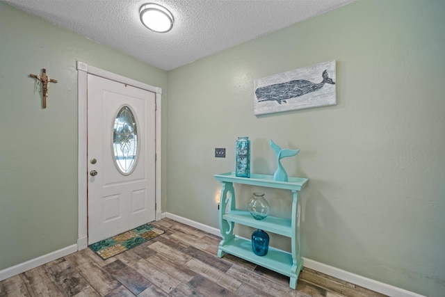 entryway featuring wood-type flooring and a textured ceiling