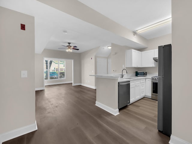 kitchen featuring a ceiling fan, a peninsula, a sink, stainless steel appliances, and open floor plan