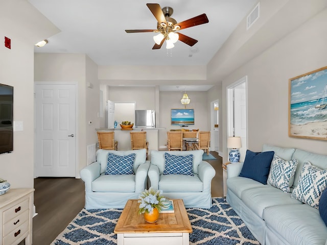 living area with ceiling fan, visible vents, and wood finished floors