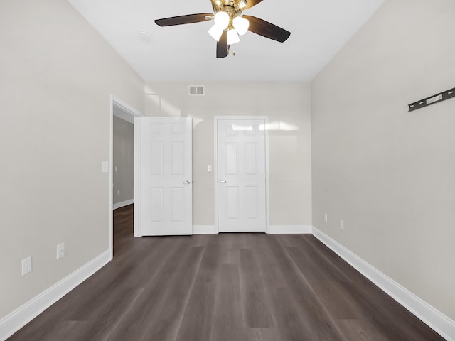 unfurnished bedroom with visible vents, baseboards, ceiling fan, and dark wood-style flooring