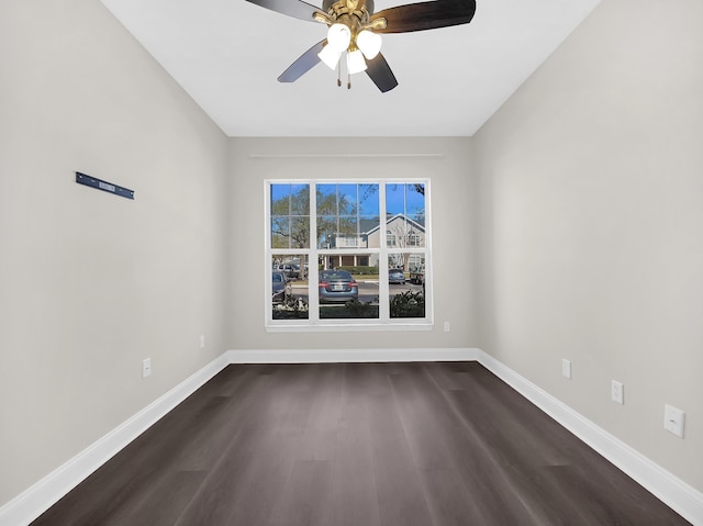 empty room featuring ceiling fan, dark wood-type flooring, and baseboards