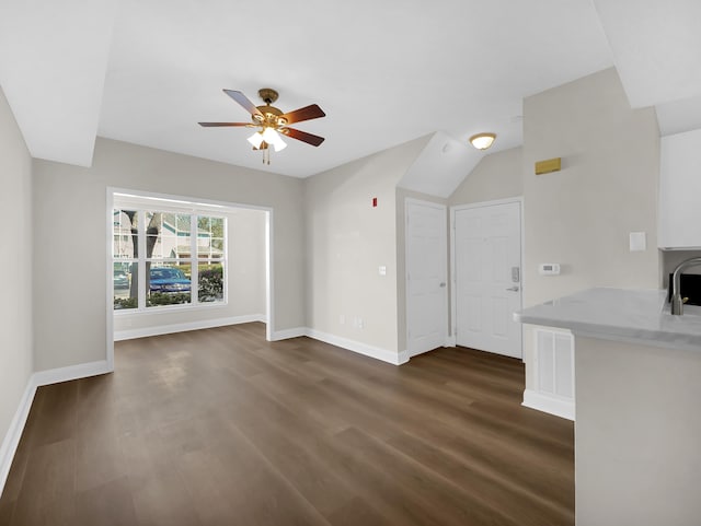 unfurnished living room with dark wood finished floors, visible vents, baseboards, and ceiling fan