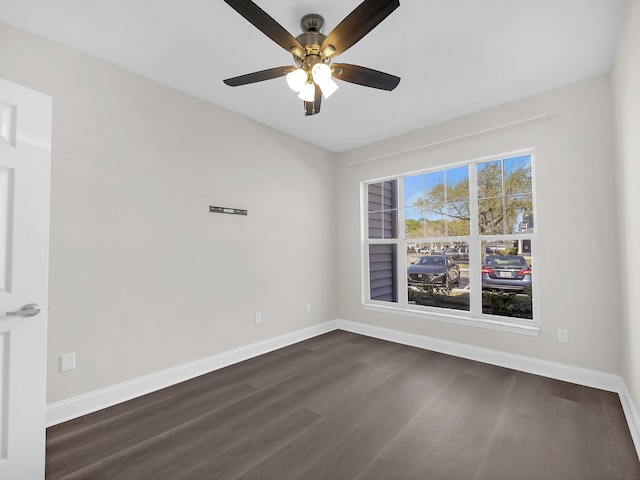 empty room featuring dark wood-style floors, ceiling fan, and baseboards