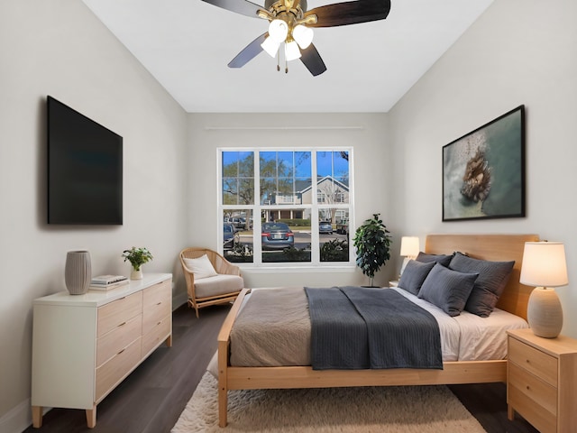 bedroom with ceiling fan, baseboards, and dark wood-type flooring