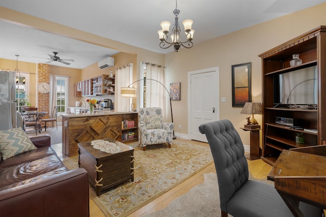 living room featuring a wall unit AC, light hardwood / wood-style flooring, and ceiling fan with notable chandelier