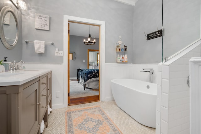 bathroom with vanity, an inviting chandelier, tile patterned floors, and a bathtub