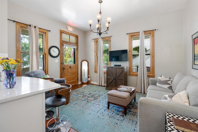 living room with hardwood / wood-style floors, a notable chandelier, and a healthy amount of sunlight